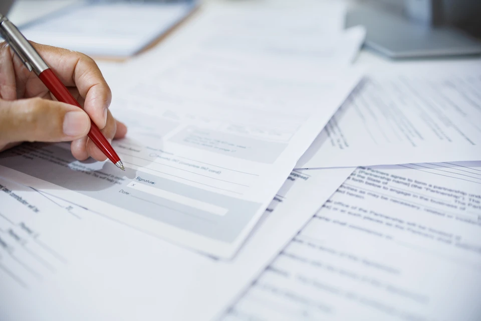 gros plan, main d'homme d'affaires examinant le document sur le bureau avant de signer un document important pour compléter le contrat d'affaires